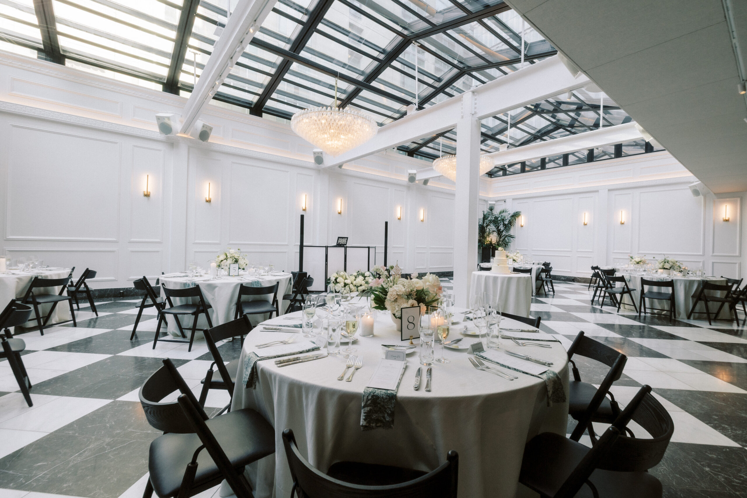 Elegant wedding reception setup at Salon 61 Events in Chicago, featuring round tables with floral centerpieces and modern black chairs