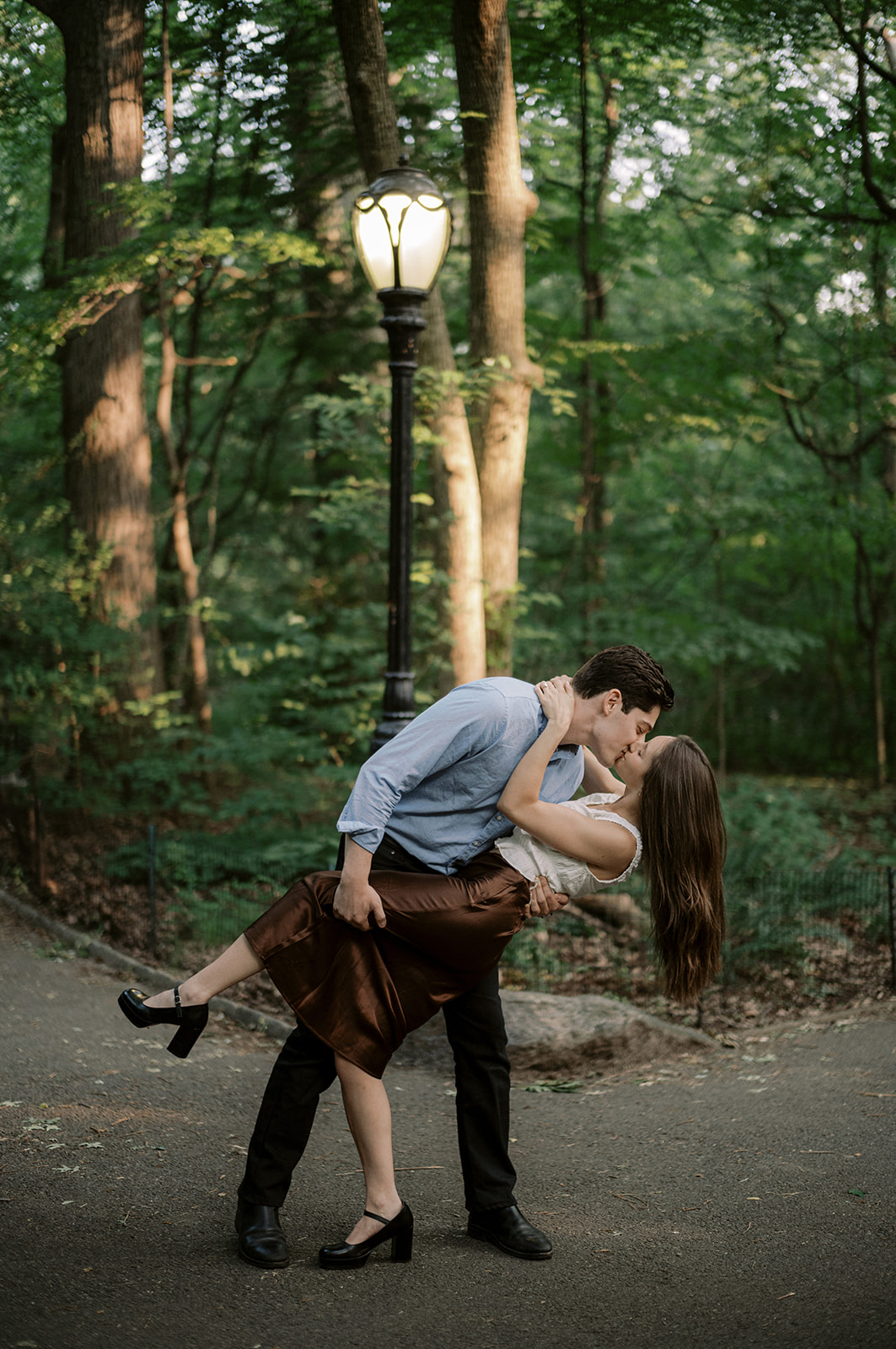 NYC engagement session featuring a couple in a dip kiss under a classic Central Park lamppost