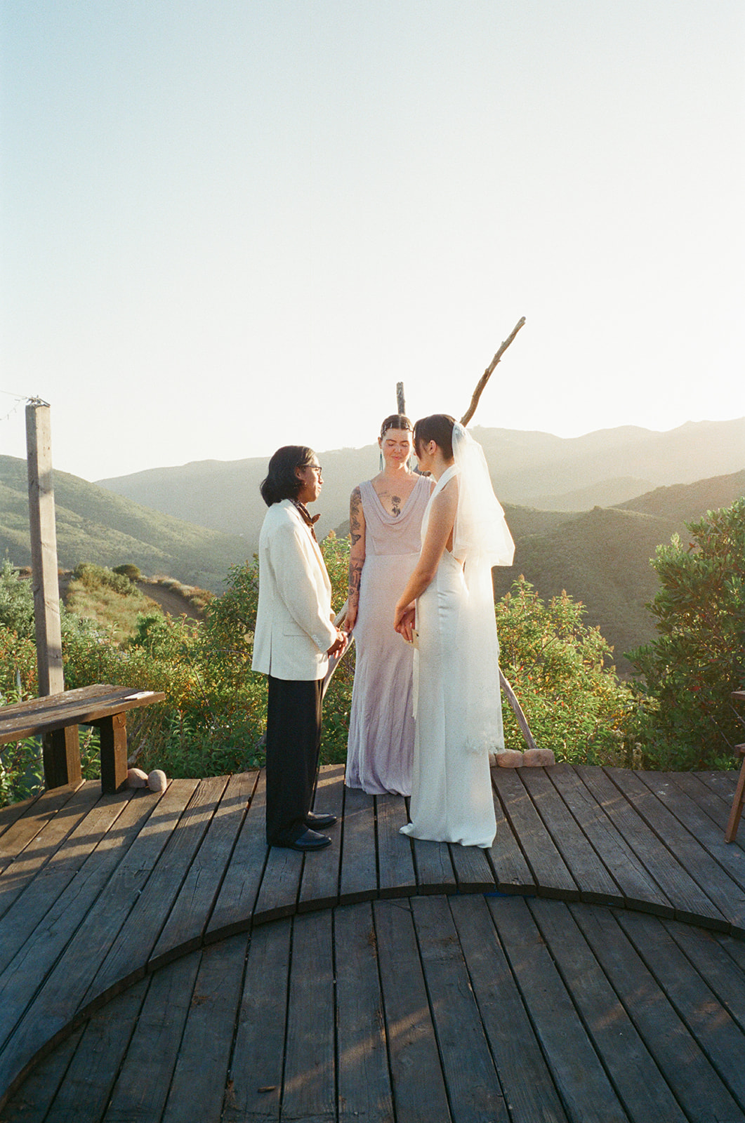 Outdoor wedding ceremony on a wooden deck at Wild Malibu Film Retreat with Malibu mountain views behind the couple