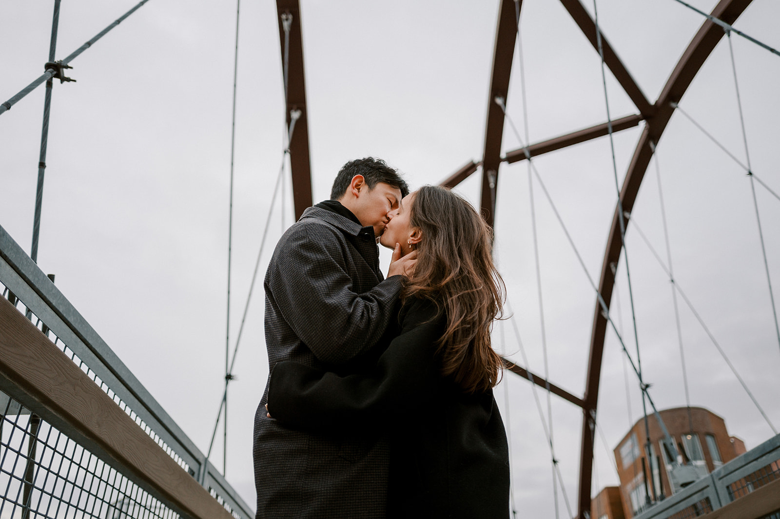 Couple kissing during a Chicago engagement session on a bridge, documentary style