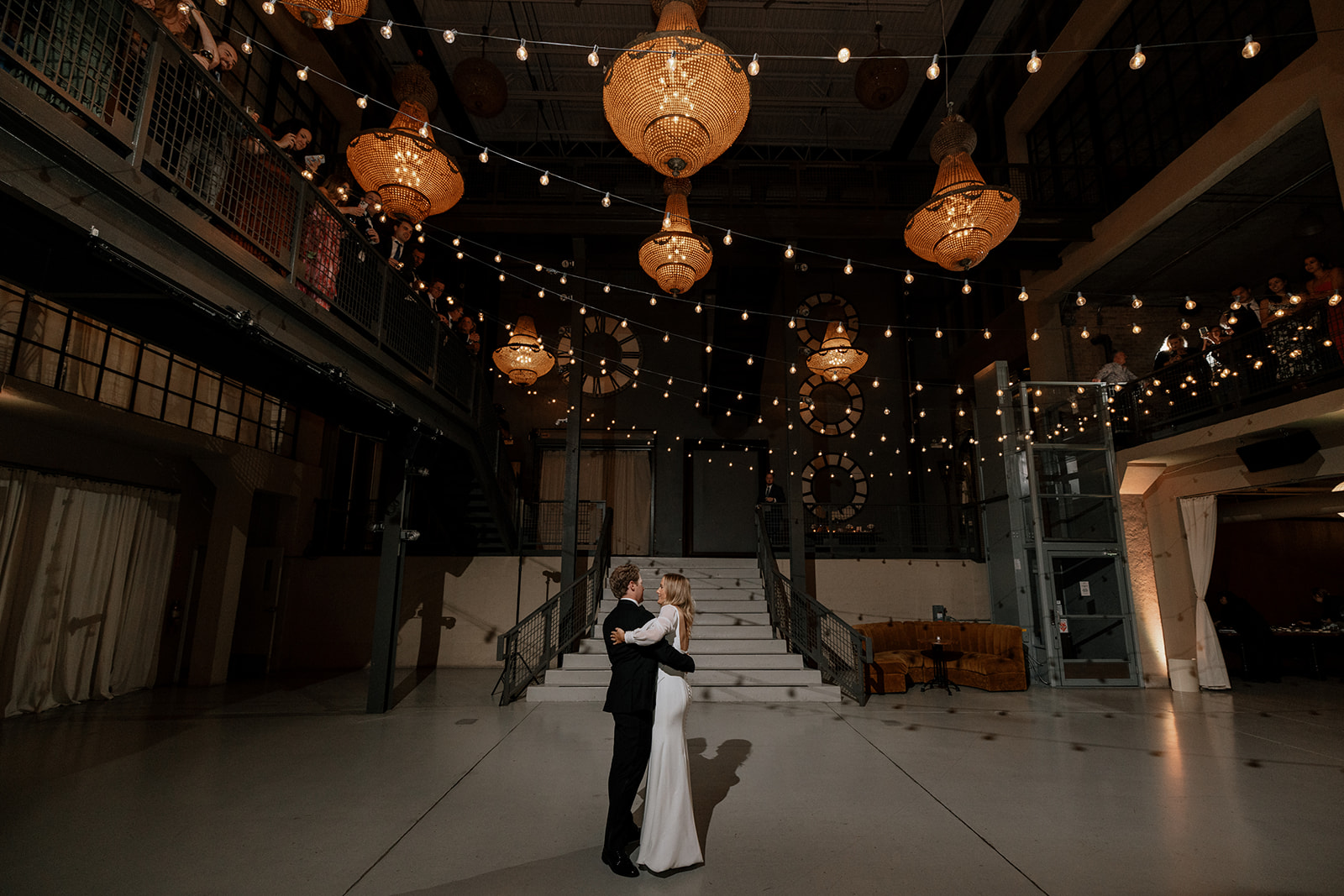 Bride and groom sharing their first dance during an Artifact Events wedding reception in Chicago beneath chandelier lights.